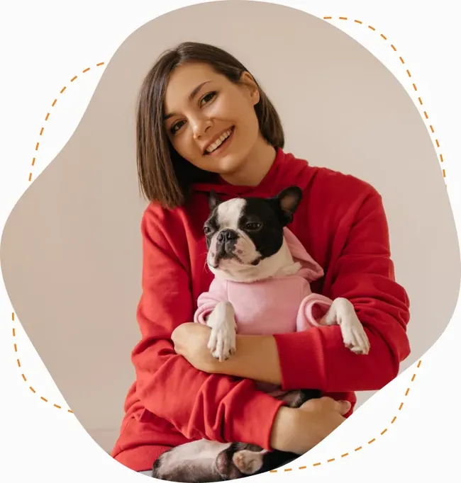 Chica con suéter rojo abrazando a su bulldog francés